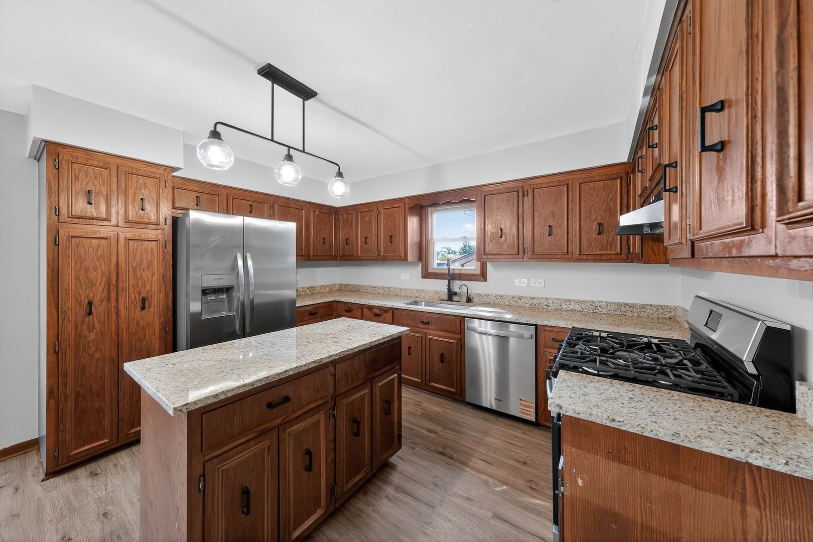7501 Cambridge Road Darien, IL 60561 - Photo 13 of 22 a kitchen with stainless steel appliances granite countertop a sink stove a refrigerator and cabinets