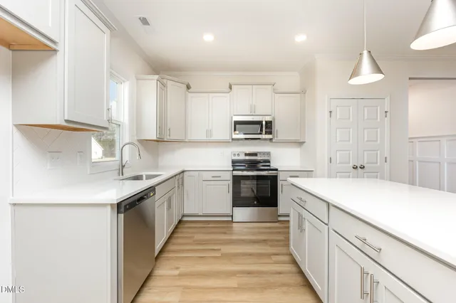 a kitchen with kitchen island granite countertop a sink and steel appliances