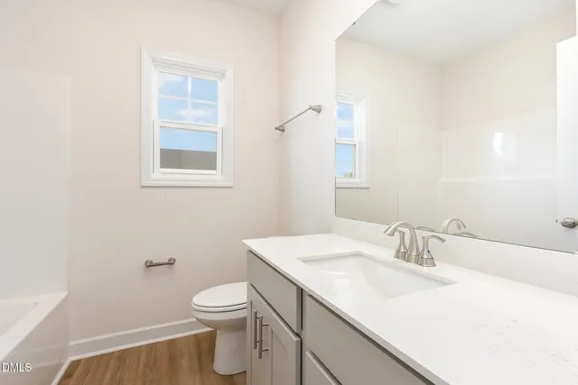 a bathroom with a sink toilet and a mirror