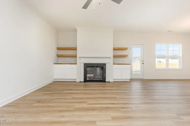 a view of an empty room with a window and fireplace