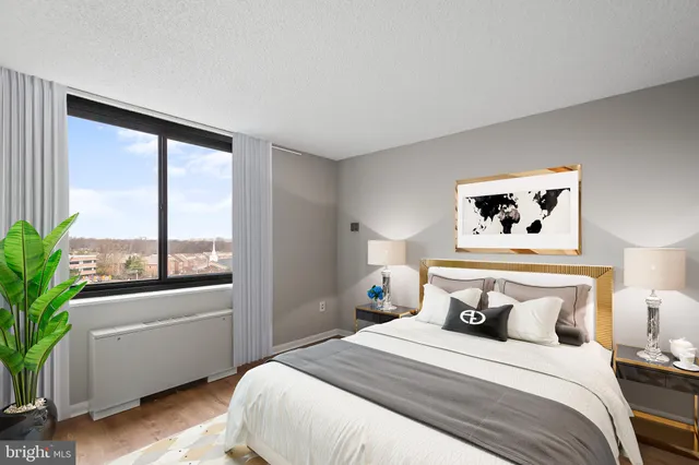 a bedroom with a large bed and a potted plant