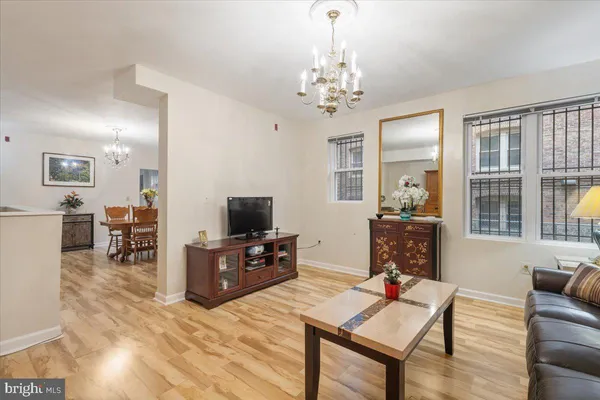 a living room with furniture a chandelier a rug and a window