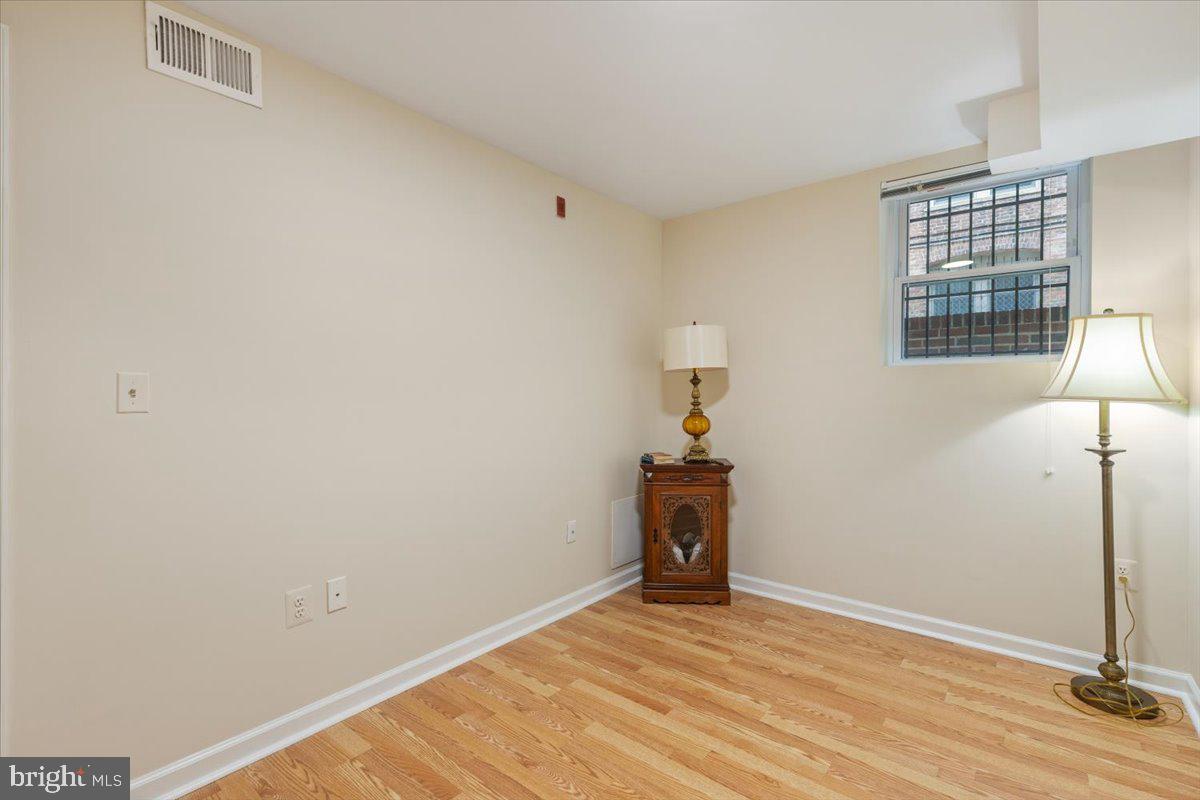 1458 Columbia Road Northwest, Unit 105 Washington, DC 20009 - Photo 16 of 39 a view of an empty room with window and wooden floor