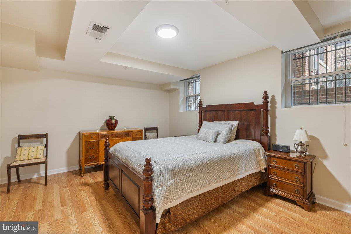 1458 Columbia Road Northwest, Unit 105 Washington, DC 20009 - Photo 20 of 39 a bedroom with a bed and wooden floor