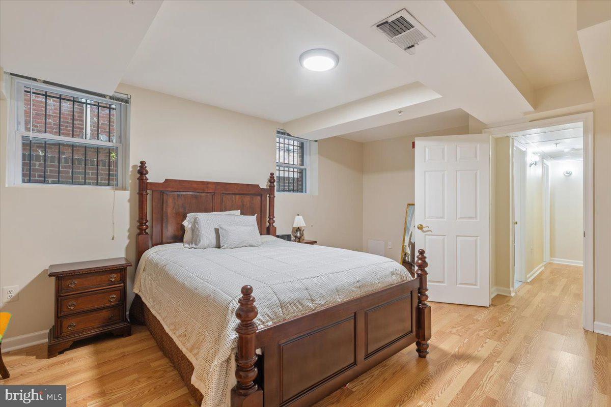 1458 Columbia Road Northwest, Unit 105 Washington, DC 20009 - Photo 22 of 39 a bedroom with a bed and wooden floor