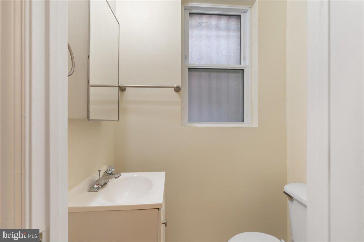 1458 Columbia Road Northwest, Unit 105 Washington, DC 20009 - Photo 10 of 39 a bathroom with a sink a toilet and vanity