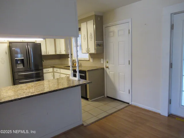 a kitchen with stainless steel appliances granite countertop a sink and a refrigerator