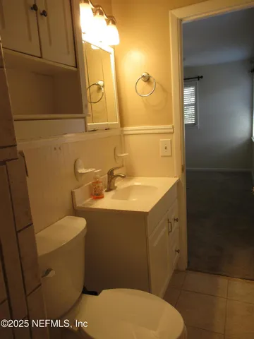 a bathroom with a sink a toilet and mirror