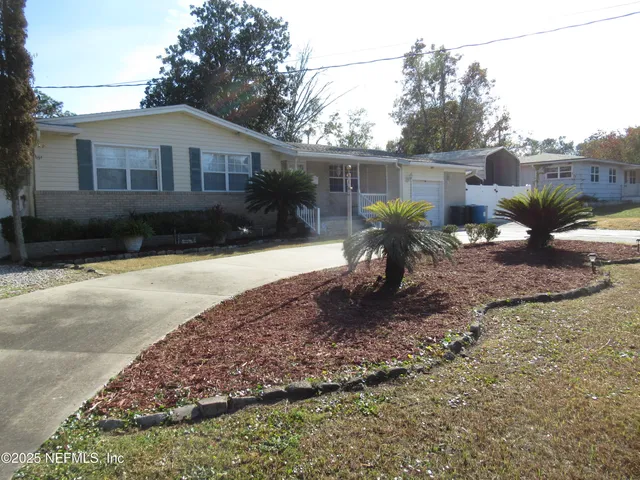 a view of a house with backyard and a tree