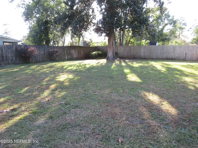 a view of a yard with large trees