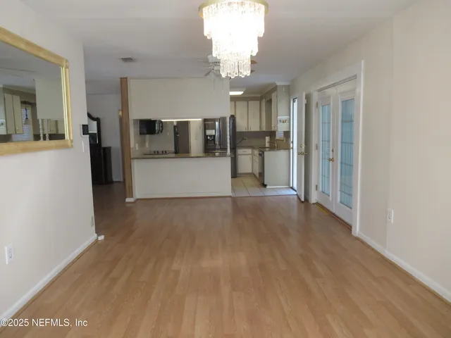 a view of a big room with wooden floor and chandelier