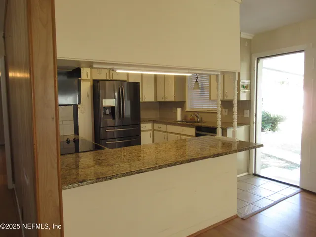 a large kitchen with stainless steel appliances granite countertop a refrigerator and a sink