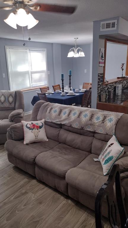 304 Ridgewood Drive Tool, TX 75143 - Photo 6 of 12 Living area with wood finished floors, ceiling fan, and a chandelier