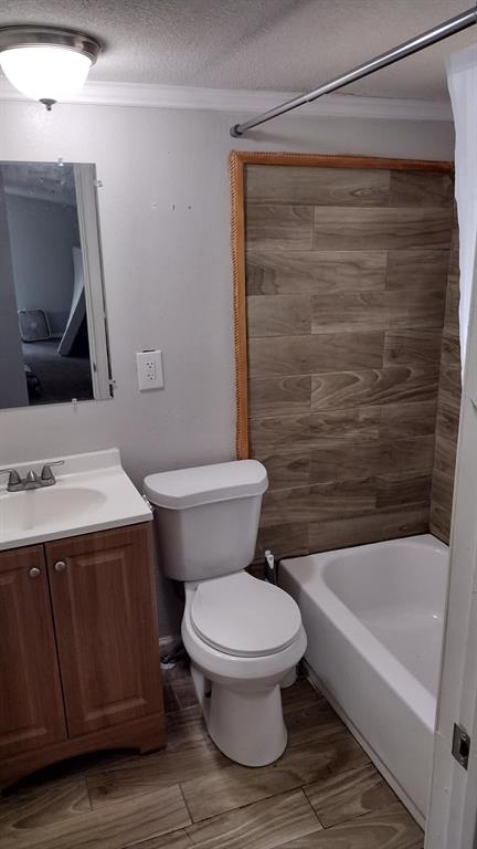 304 Ridgewood Drive Tool, TX 75143 - Photo 7 of 12 Bathroom with vanity, shower / bathtub combination with curtain, ornamental molding, a textured ceiling, and wood finish floors