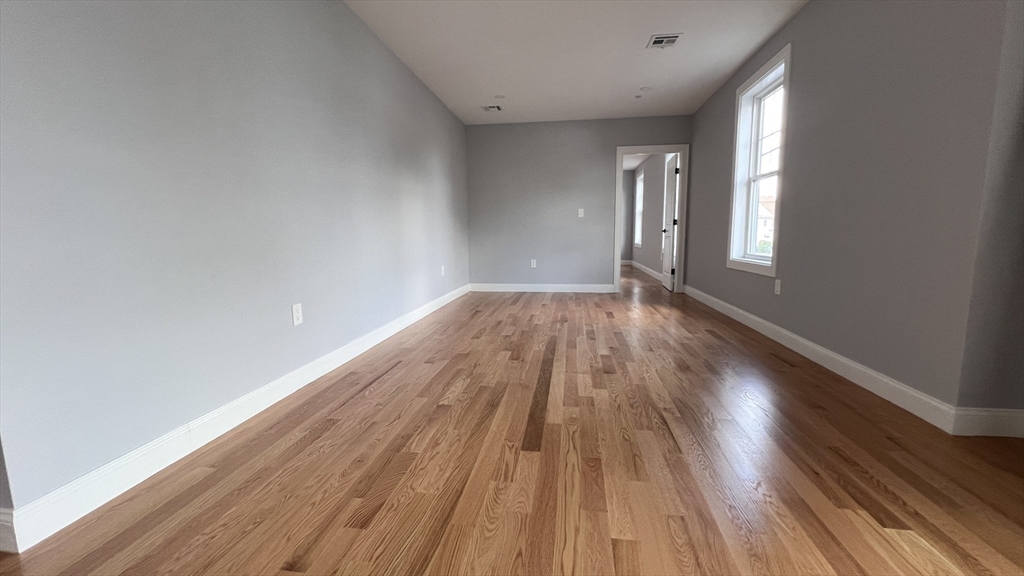 585 Washington Street, Unit MODEL2 Quincy, MA 02169 - Photo 3 of 10 a view of an empty room and wooden floor