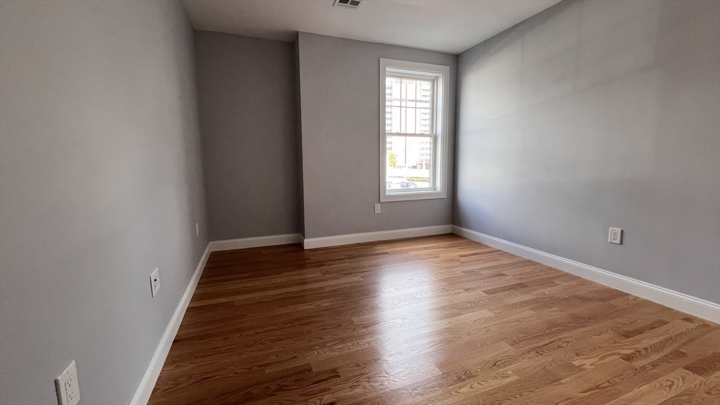 585 Washington Street, Unit MODEL2 Quincy, MA 02169 - Photo 8 of 10 wooden floor in an empty room with a window