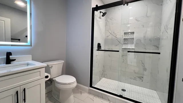 a bathroom with a shower toilet and sink