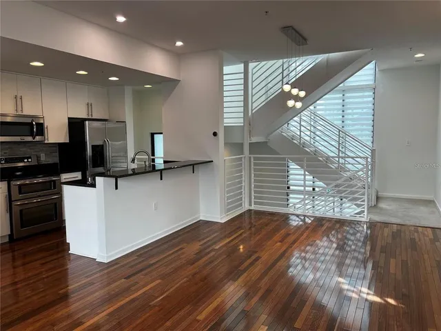 a view of kitchen with wooden floor and electronic appliances