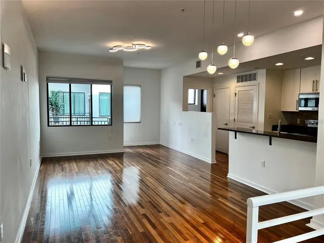a view of a kitchen with wooden floor and a window