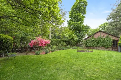 a view of a backyard with a garden and entertaining space