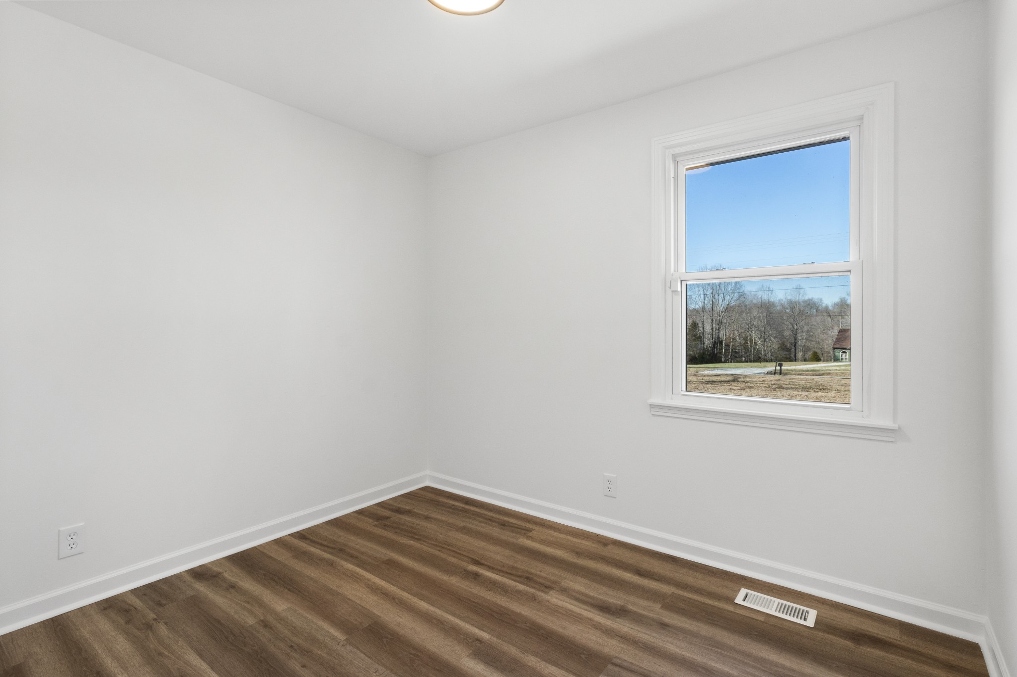 1402 Southside Road Southside, TN 37171 - Photo 14 of 24 a view of an empty room with wooden floor and a window
