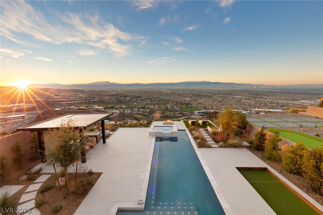 571 Overlook Rim Drive Henderson, NV 89012 - Photo 55 of 85 Pool at dusk with an outdoor pool, a mountain view, and a patio