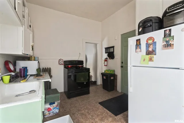 a kitchen with a refrigerator and a stove top oven