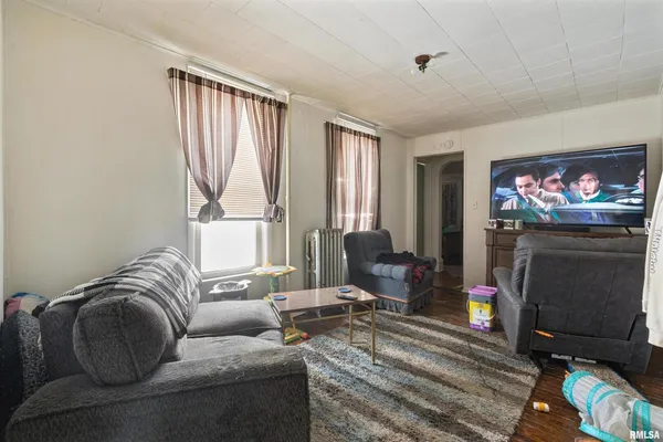 a living room with furniture a flat screen tv and a fireplace