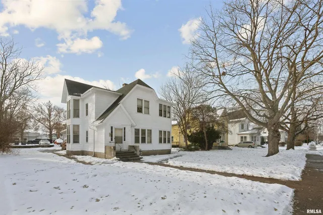 a view of a white house with a snow on the road
