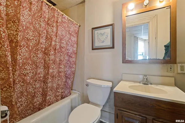 a bathroom with a granite countertop toilet and a sink