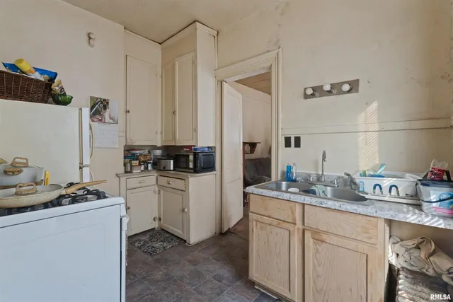a kitchen with sink refrigerator and stove