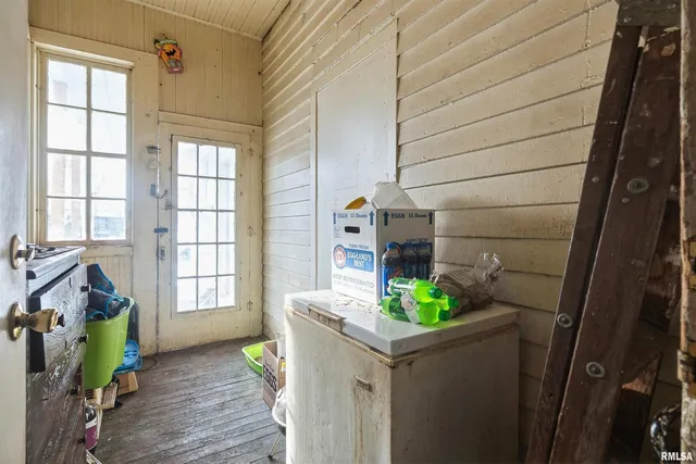a hallway with front door and wooden floor