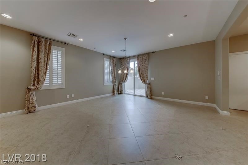 3144 Whitfeild Avenue Henderson, NV 89044 - Photo 7 of 55 A well-lit, neutral-toned room features tile flooring and convenient sliding glass doors leading to outdoor space.