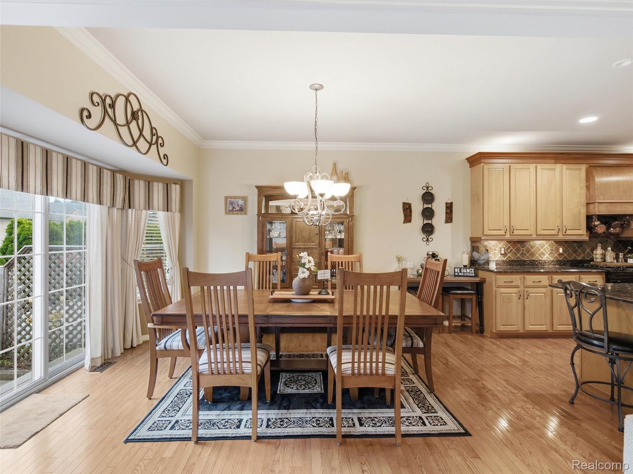 2633 Ridgecrest Drive Utica, MI 48316 - Photo 7 of 28 Open-concept dining area featuring wood flooring, a contemporary chandelier, and crown molding