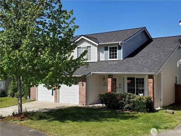a front view of a house with a yard and garage