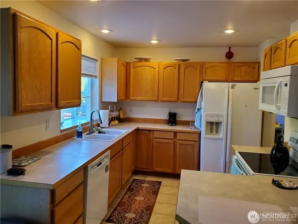 a kitchen with stainless steel appliances granite countertop a sink refrigerator and cabinets