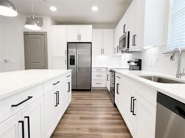 a kitchen with white cabinets appliances and sink