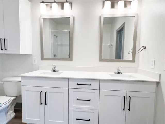 a spacious bathroom with a double vanity sink a mirror and a bathtub