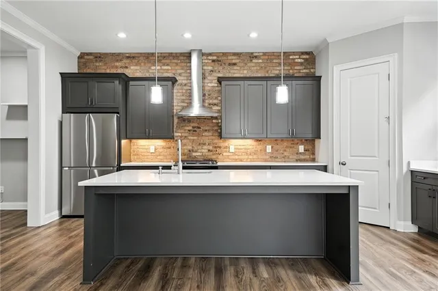 a kitchen with kitchen island granite countertop a sink and refrigerator