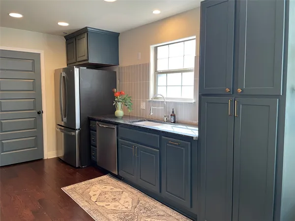 a kitchen with stainless steel appliances granite countertop a refrigerator and a sink