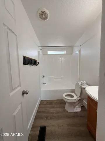 a view of an empty room with wooden floor and stairs