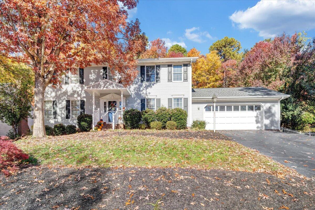 a view of a white house with a yard and plants