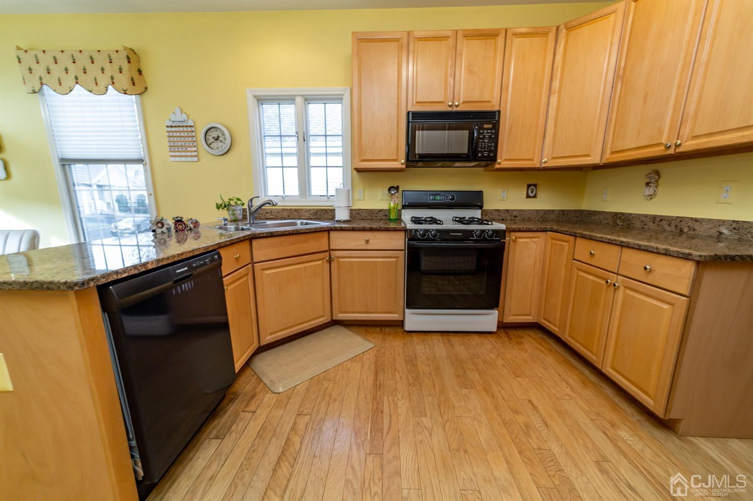 15 Stryker Road Somerset, NJ 08873 - Photo 7 of 24 a kitchen with stainless steel appliances granite countertop wooden cabinets a sink a stove a refrigerator and dishwasher with wooden floor