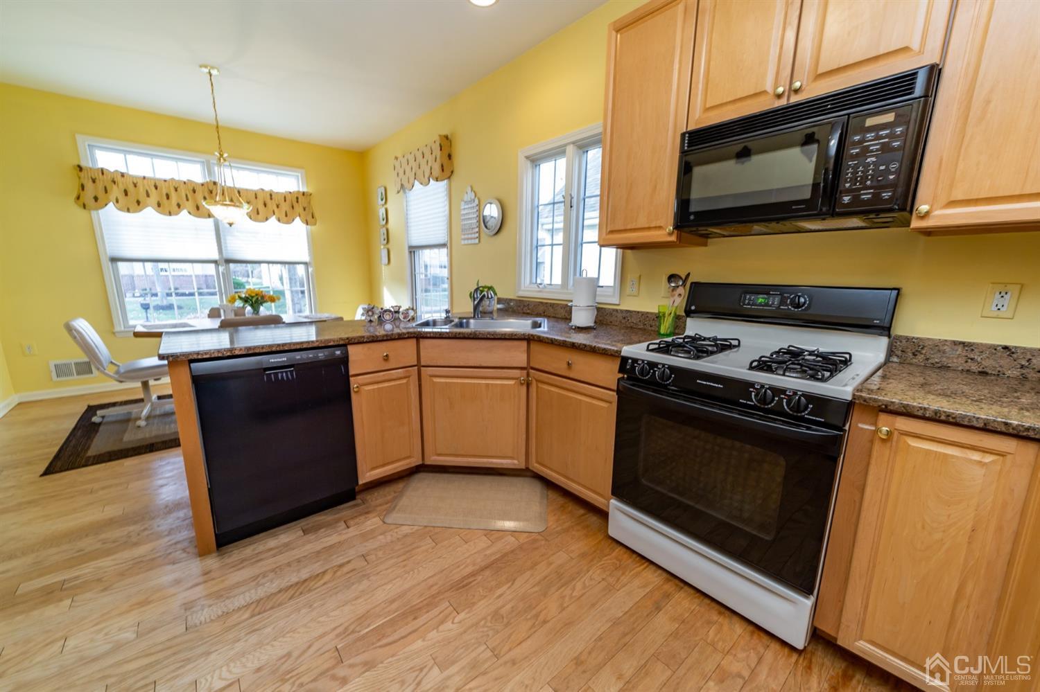 15 Stryker Road Somerset, NJ 08873 - Photo 8 of 24 a kitchen with stainless steel appliances granite countertop a stove a sink and a microwave