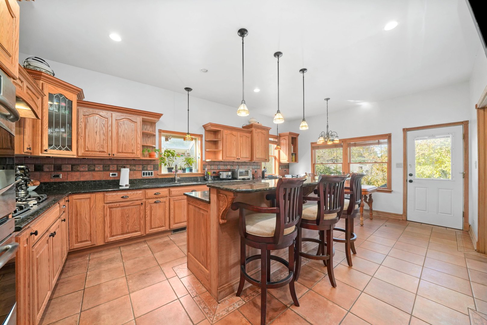 296 Addison Road Riverside, IL 60546 - Photo 9 of 34 a kitchen with stainless steel appliances granite countertop wooden cabinets a dining table and chairs