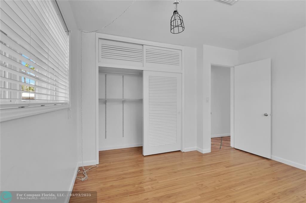 341 Southeast 8th Street Pompano Beach, FL 33060 - Photo 18 of 56 a view of an empty room with wooden floor and a window