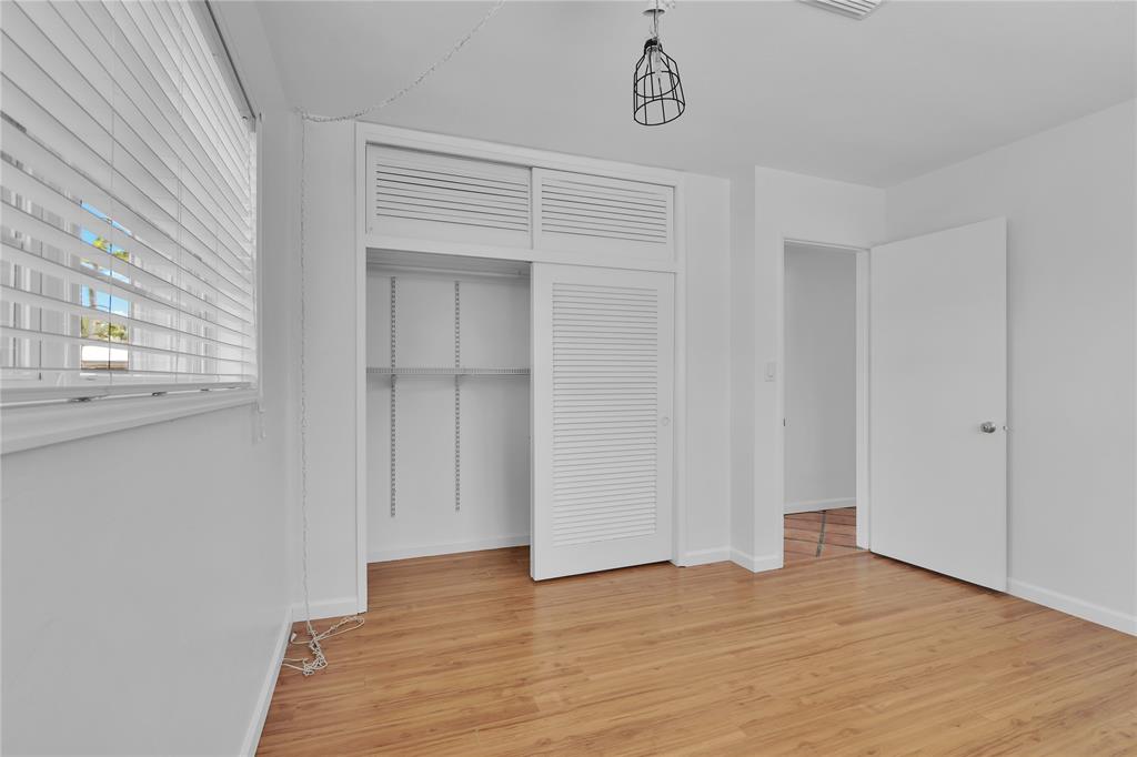 341 Southeast 8th Street Pompano Beach, FL 33060 - Photo 18 of 56 a view of an empty room with wooden floor and a window