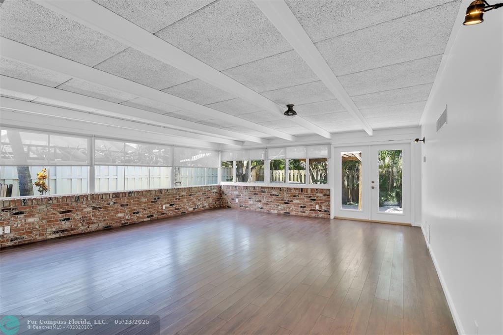341 Southeast 8th Street Pompano Beach, FL 33060 - Photo 2 of 56 a view of an empty room with wooden floor and a window