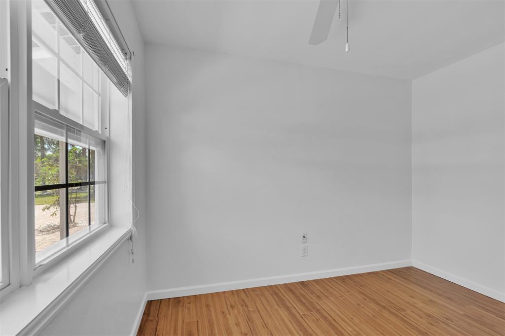 341 Southeast 8th Street Pompano Beach, FL 33060 - Photo 26 of 56 an empty room with wooden floor and windows