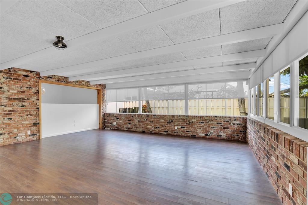 341 Southeast 8th Street Pompano Beach, FL 33060 - Photo 3 of 56 a view of an empty room with wooden floor and a window